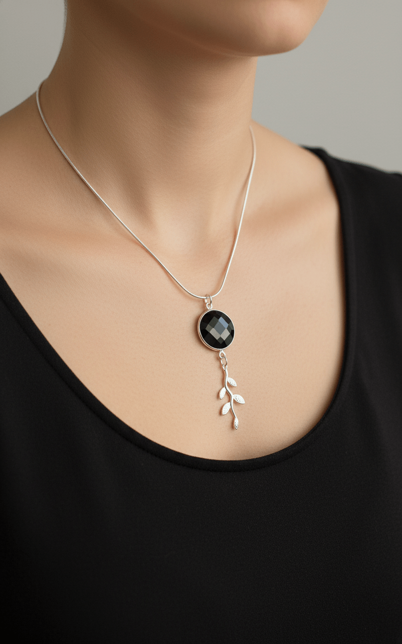 Model wearing black onyx and leaf necklace with black top