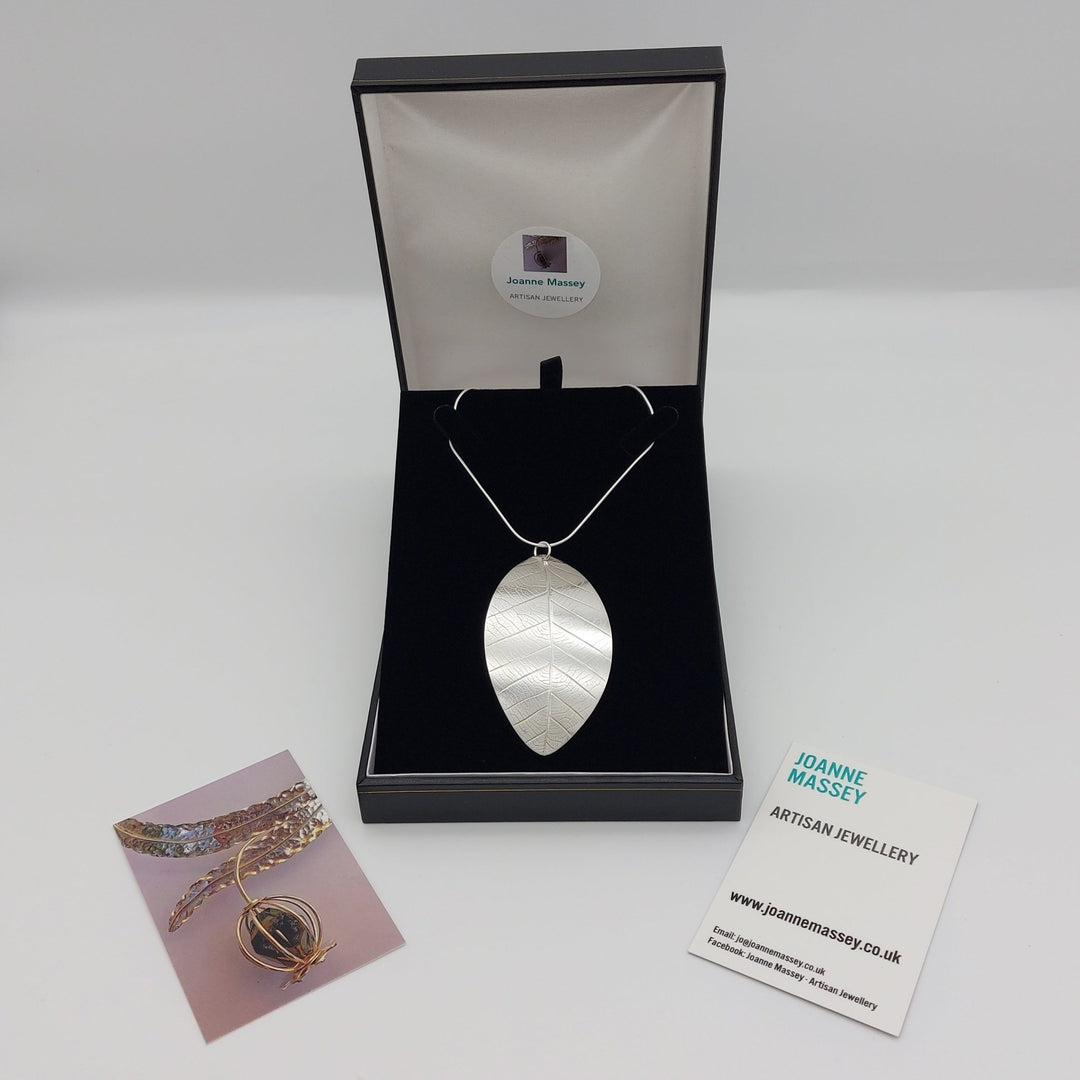 Silver leaf pendant necklace in a black display box with Joanne Massey Artisan Jewellery business cards.