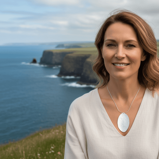 Woman wearing sterling silver leaf bark texture necklace on 18-inch chain with Welsh coast