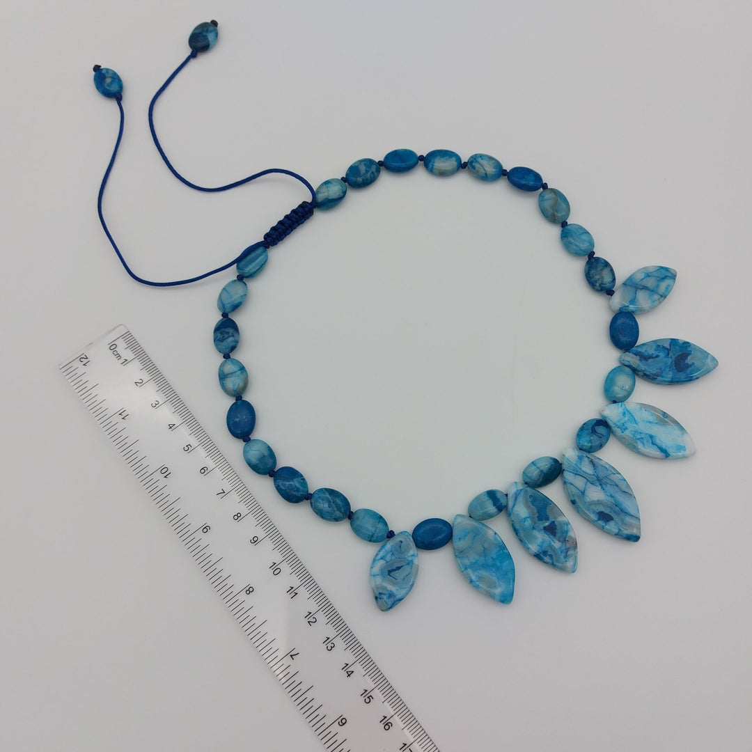Adjustable Blue Crazy Lace Agate gemstone necklace laid flat beside measuring ruler