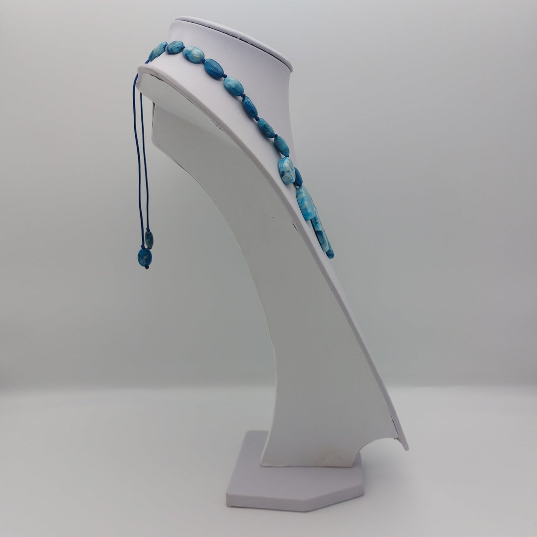 Side view of Blue Crazy Lace Agate gemstone necklace on white jewellery display
