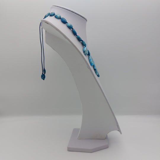 Side view of Blue Crazy Lace Agate gemstone necklace on white jewellery display