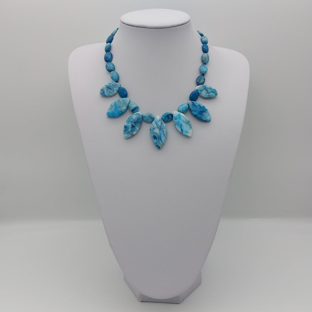 Full Blue Crazy Lace Agate statement necklace displayed on a white jewellery bust