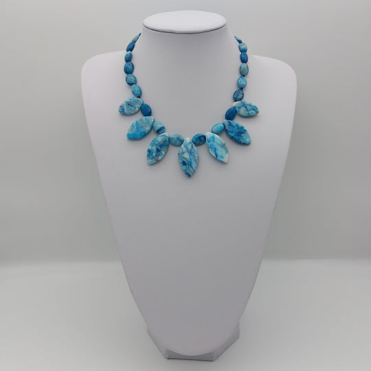Full Blue Crazy Lace Agate statement necklace displayed on a white jewellery bust
