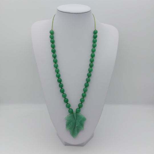 Green aventurine carved leaf adjustable necklace displayed at a longer length