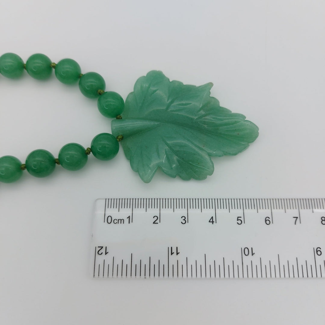 Close-up measurement of genuine green aventurine carved leaf pendant approximately 60 by 50mm