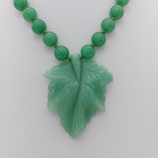Close-up of carved green aventurine leaf pendant with 10mm genuine gemstone beads