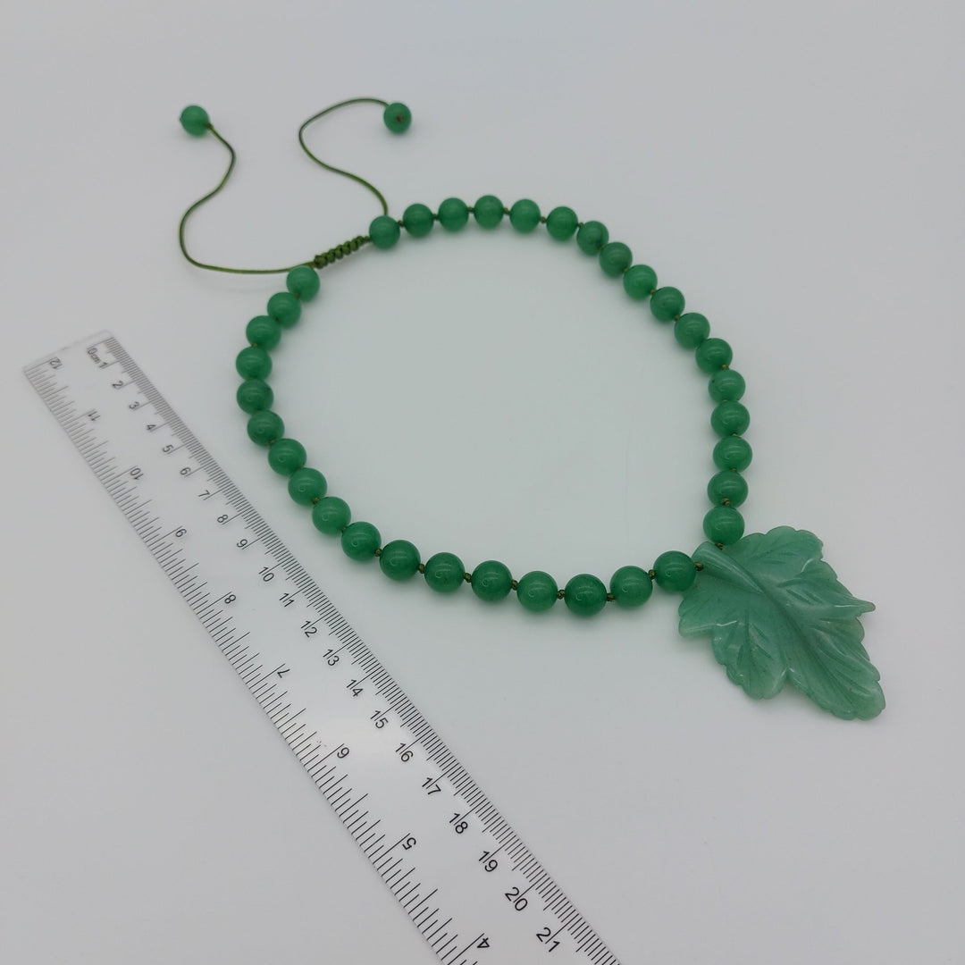 Green aventurine carved leaf necklace photographed with ruler to show necklace proportions